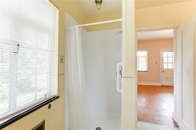 bathroom with hardwood / wood-style flooring and a shower with curtain