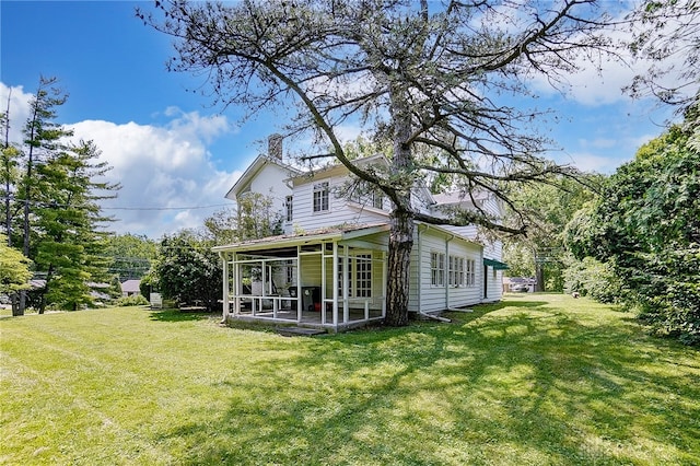 back of house featuring a lawn