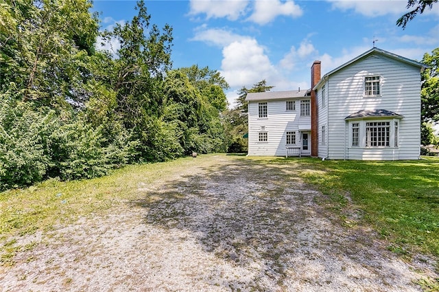 rear view of property featuring a lawn