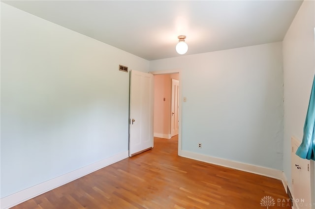 empty room with hardwood / wood-style flooring