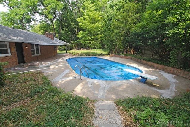 view of pool featuring a diving board and a patio area