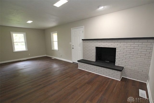 unfurnished living room with a fireplace and dark wood-type flooring