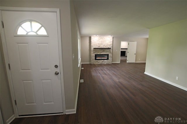 foyer with dark hardwood / wood-style flooring and a stone fireplace