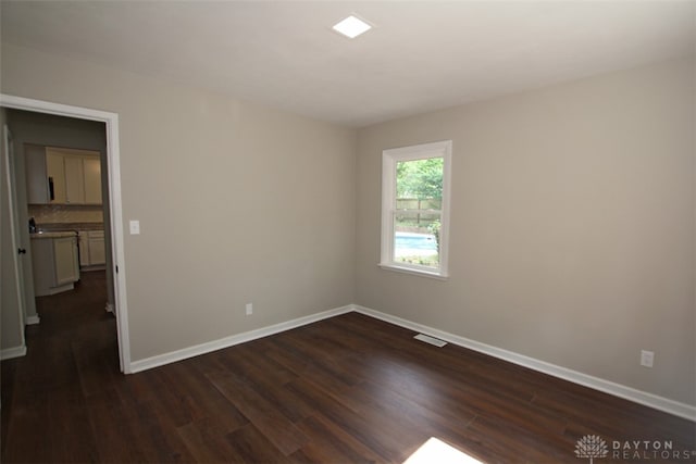 spare room featuring dark wood-type flooring