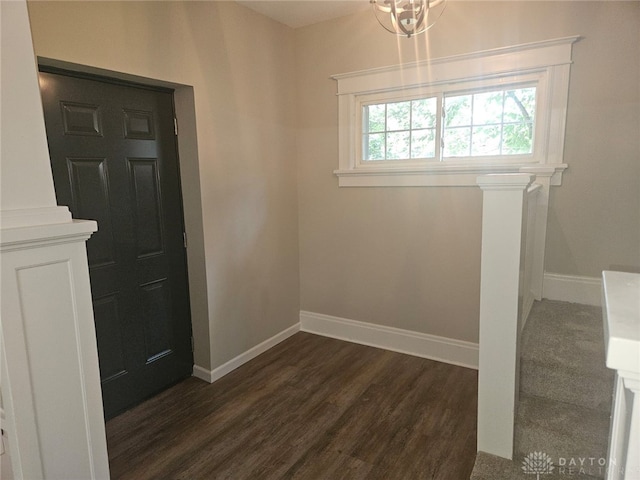 entrance foyer with an inviting chandelier and dark hardwood / wood-style flooring