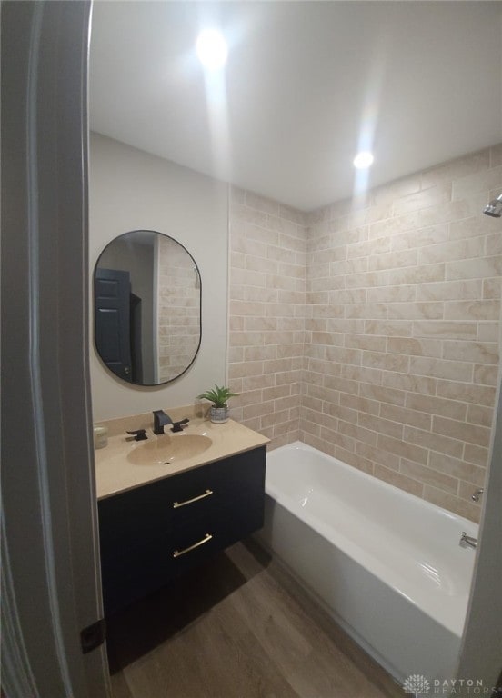 bathroom featuring vanity, tiled shower / bath, and hardwood / wood-style flooring