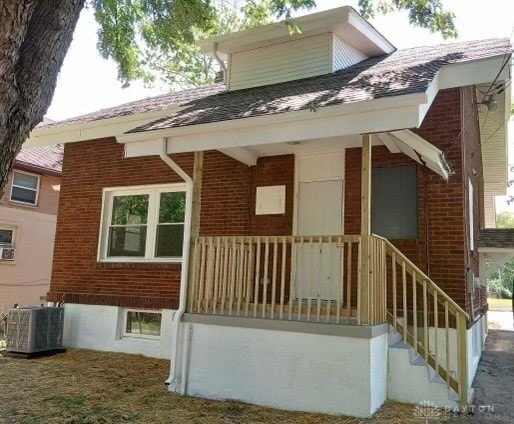 rear view of property featuring cooling unit and a porch