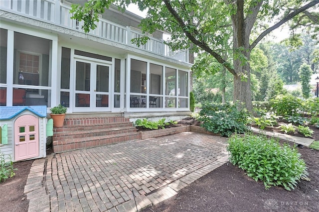 view of patio featuring a balcony and a sunroom