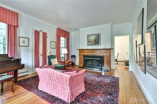 living room with hardwood / wood-style flooring, a baseboard heating unit, and ornamental molding