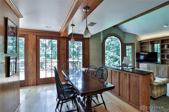 dining area featuring lofted ceiling, built in features, light wood-type flooring, and ornamental molding