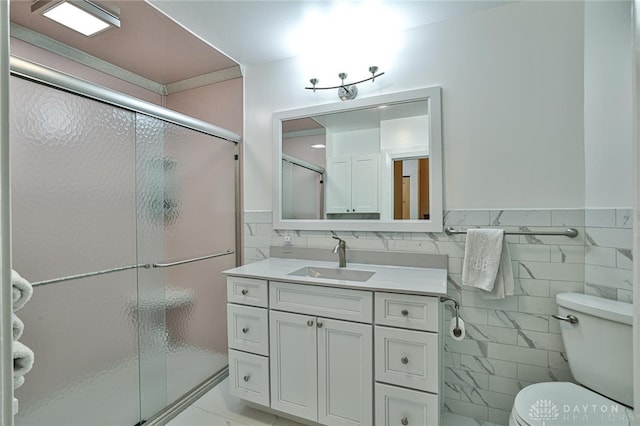 bathroom featuring an enclosed shower, vanity, and tile walls