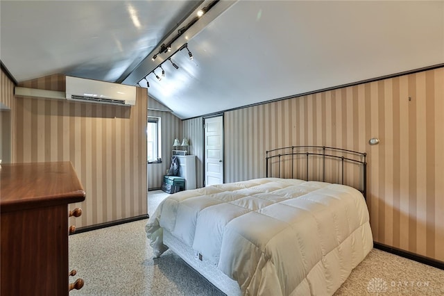 bedroom featuring a wall mounted air conditioner, rail lighting, and vaulted ceiling