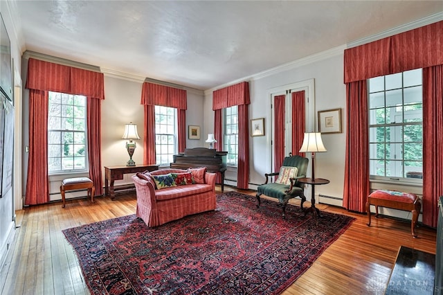 sitting room featuring hardwood / wood-style floors, ornamental molding, and a baseboard heating unit