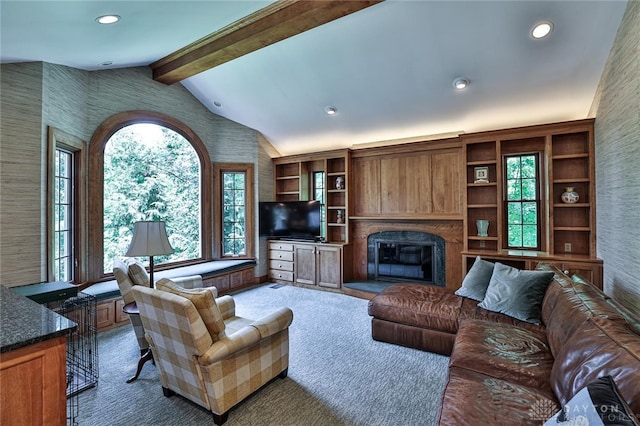 carpeted living room featuring vaulted ceiling with beams and a healthy amount of sunlight