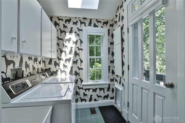 clothes washing area with cabinets, a wealth of natural light, and washer and clothes dryer