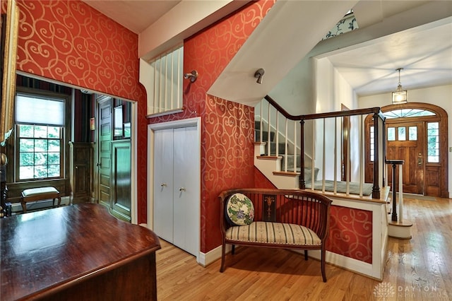 foyer entrance with hardwood / wood-style flooring, a healthy amount of sunlight, and vaulted ceiling