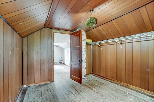 bonus room featuring lofted ceiling, wooden walls, wooden ceiling, and light wood-style floors