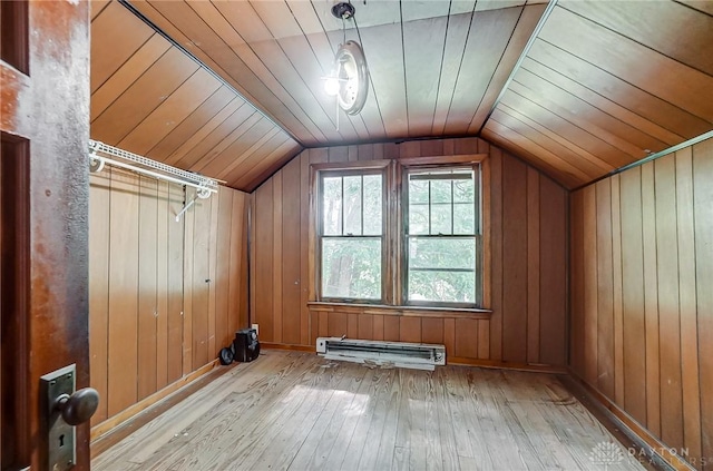 bonus room with a baseboard radiator, wood walls, lofted ceiling, and light wood finished floors