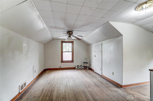 additional living space featuring vaulted ceiling, light wood-style flooring, visible vents, and baseboards