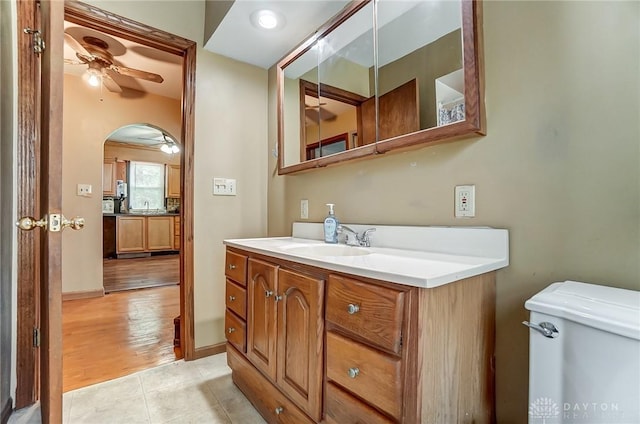 bathroom with toilet, ceiling fan, vanity, tile patterned flooring, and baseboards