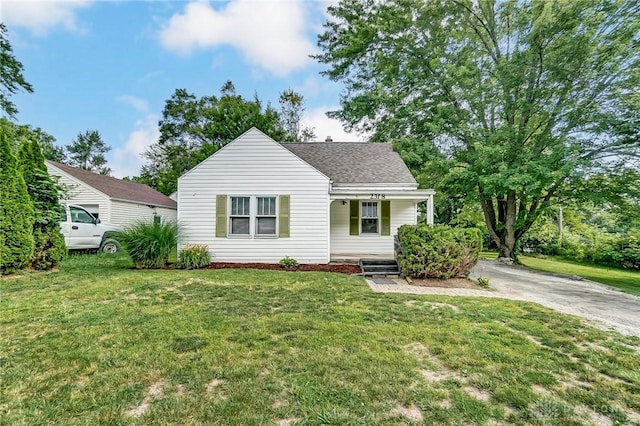 view of front of property featuring a front yard and roof with shingles