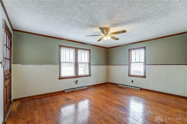 spare room with a baseboard radiator, plenty of natural light, light wood finished floors, and baseboard heating