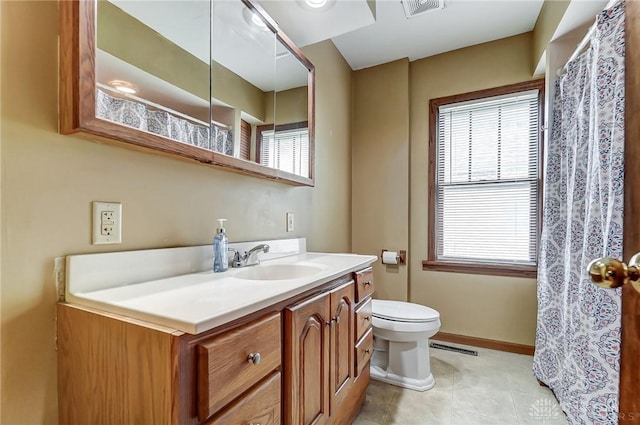 bathroom with visible vents, toilet, vanity, tile patterned flooring, and baseboards