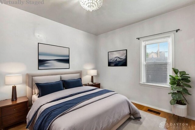 bedroom featuring a notable chandelier and hardwood / wood-style floors