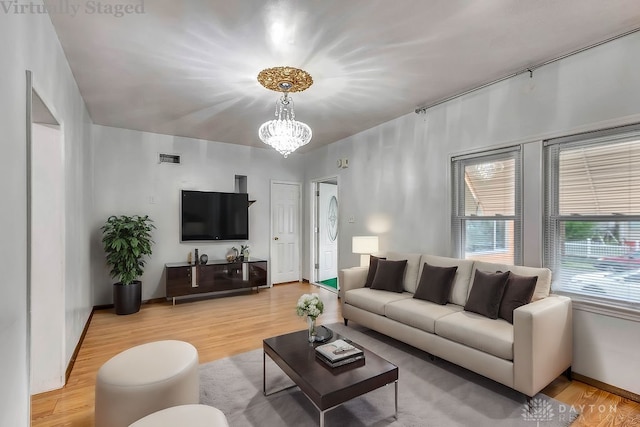 living room featuring an inviting chandelier and wood-type flooring