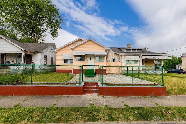 bungalow-style house with a front lawn, a fenced front yard, and a gate