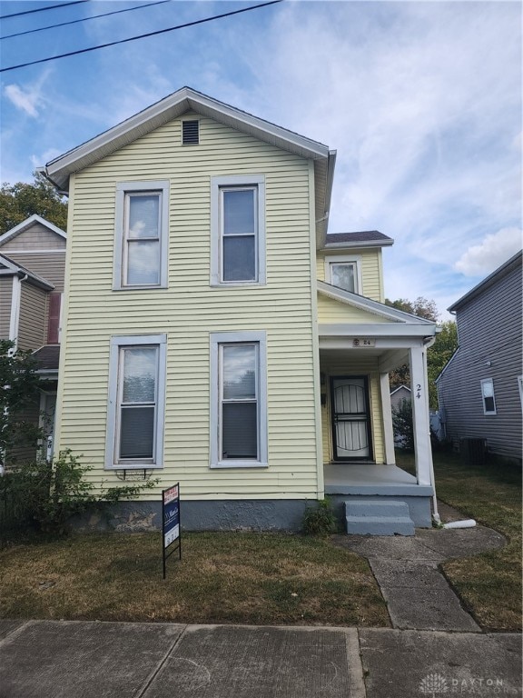 view of front of property with a front lawn, central AC unit, and a porch