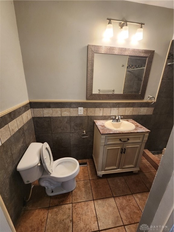 bathroom featuring vanity, tasteful backsplash, tile walls, toilet, and tile patterned floors