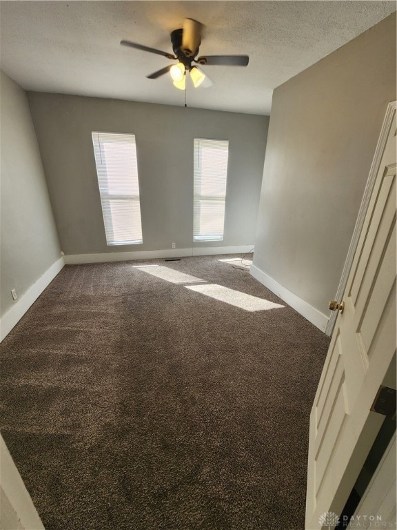 carpeted empty room featuring ceiling fan and a textured ceiling