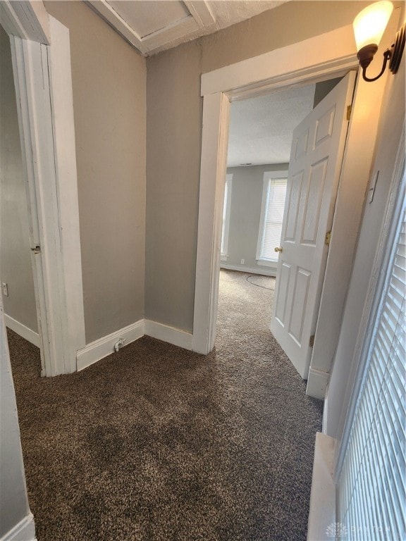 hallway featuring dark carpet