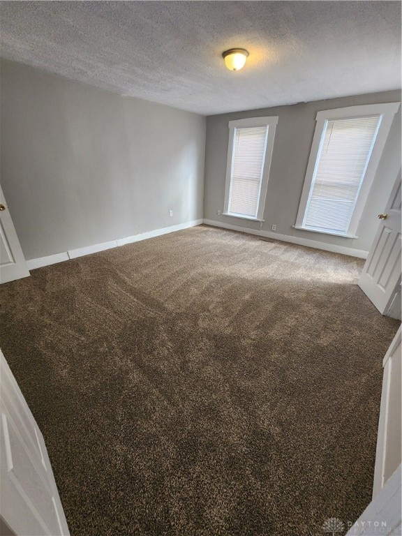 spare room with a textured ceiling and carpet