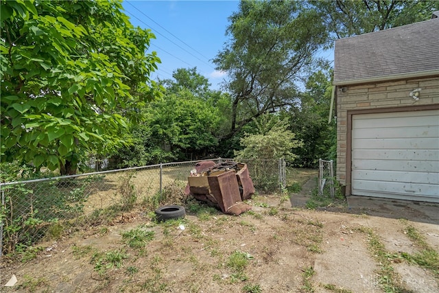 view of yard with a garage and an outbuilding