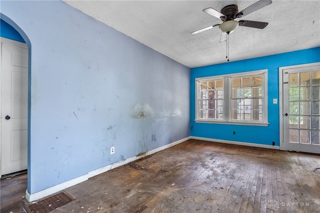 empty room featuring a textured ceiling, ceiling fan, and wood-type flooring