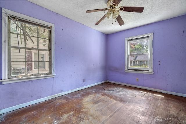 spare room featuring a textured ceiling, ceiling fan, and wood-type flooring