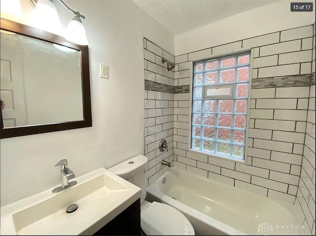 full bathroom featuring tiled shower / bath combo, toilet, a textured ceiling, and vanity