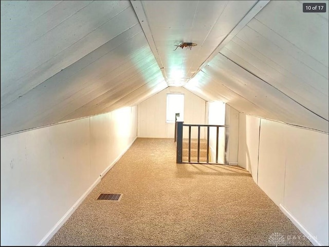 additional living space with light colored carpet and lofted ceiling