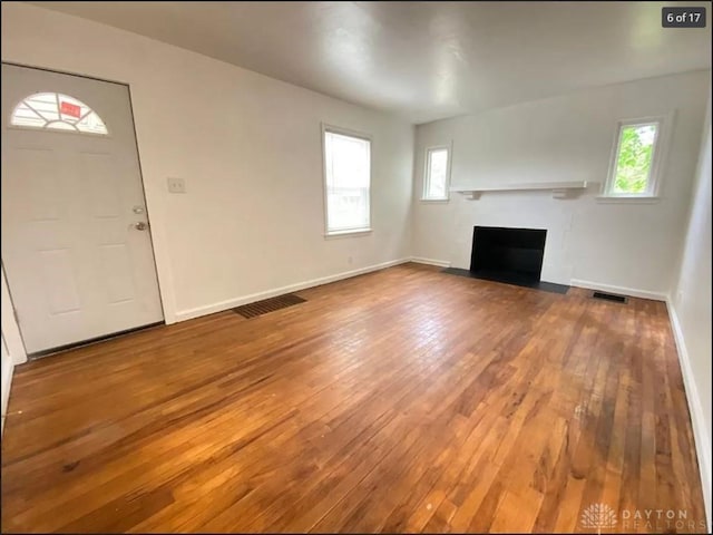 unfurnished living room with plenty of natural light and wood-type flooring