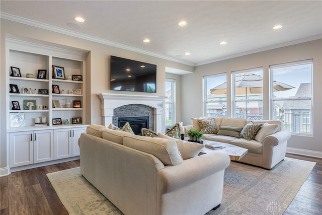 living room with dark hardwood / wood-style flooring, a stone fireplace, a healthy amount of sunlight, and crown molding