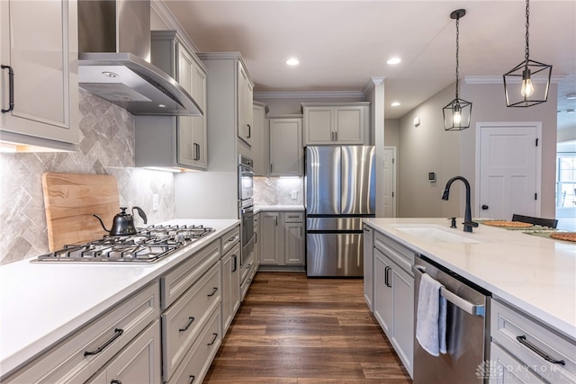 kitchen featuring gray cabinetry, sink, wall chimney exhaust hood, decorative light fixtures, and stainless steel appliances