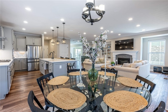 dining space featuring dark hardwood / wood-style flooring, an inviting chandelier, a wealth of natural light, and crown molding