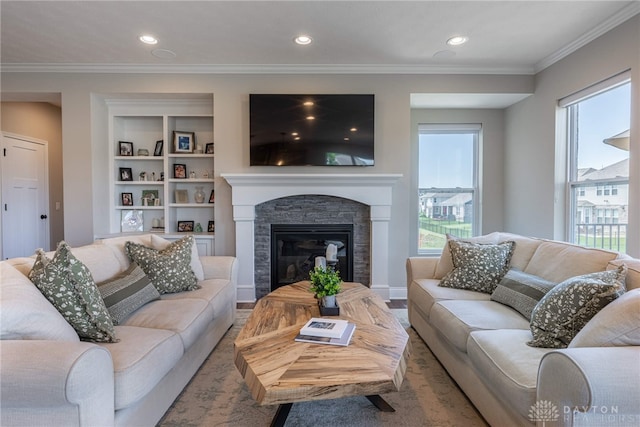 living room with a fireplace, built in shelves, and crown molding