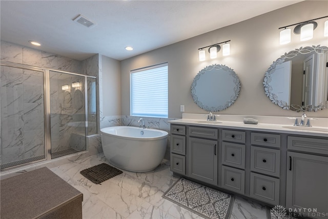 bathroom with vanity and shower with separate bathtub