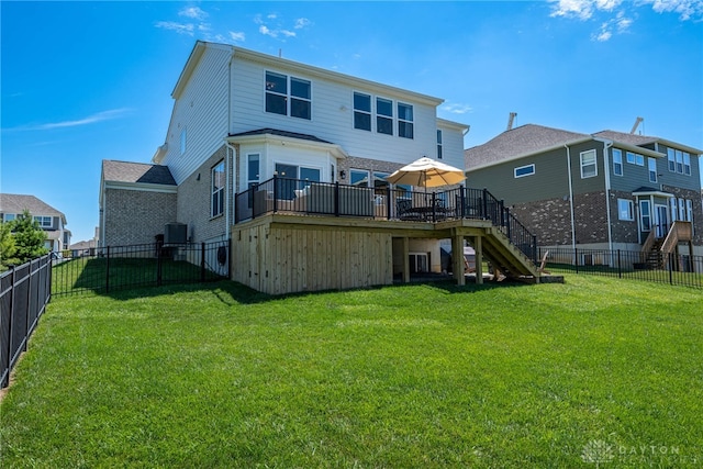 rear view of house with a yard and a wooden deck