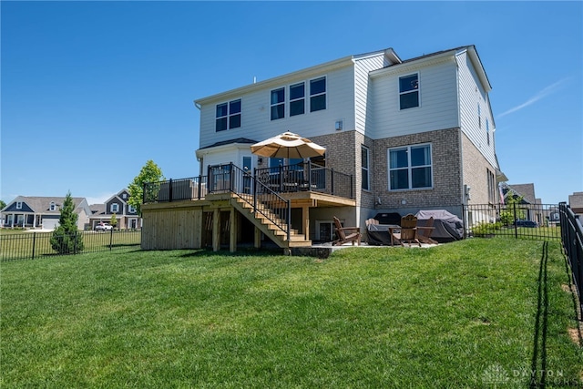 rear view of house featuring a lawn and a wooden deck