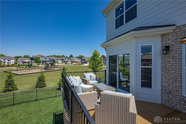 wooden terrace featuring a lawn, an outdoor living space, and a playground