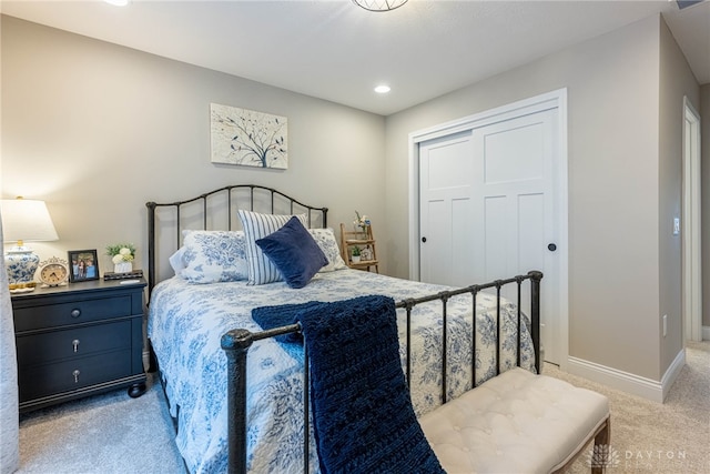 bedroom featuring light colored carpet and a closet